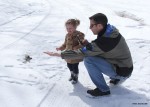 A father and daughter feeding a chickadee, photo by Jess McComb